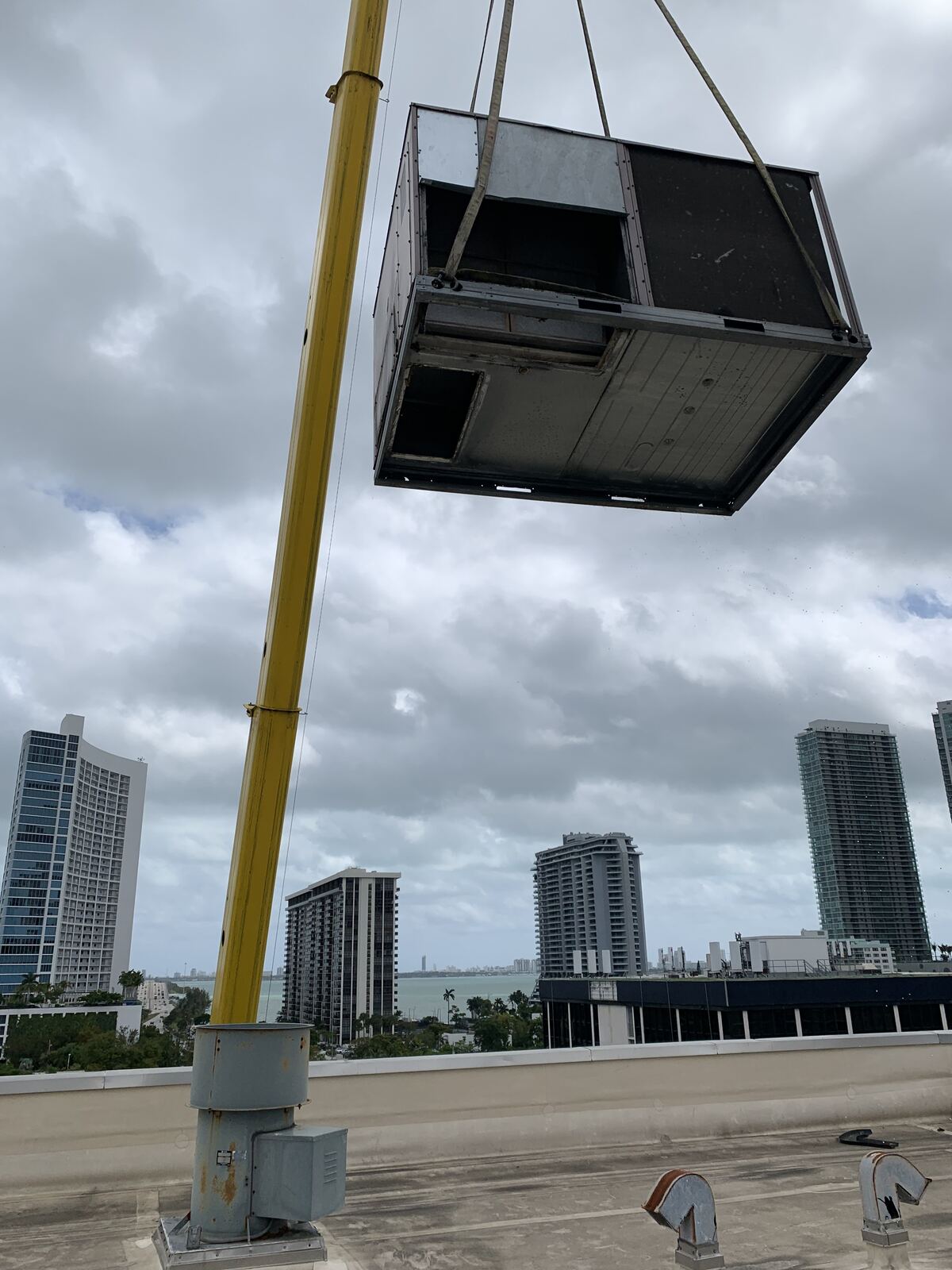 Crane lifting a rooftop air conditioning unit